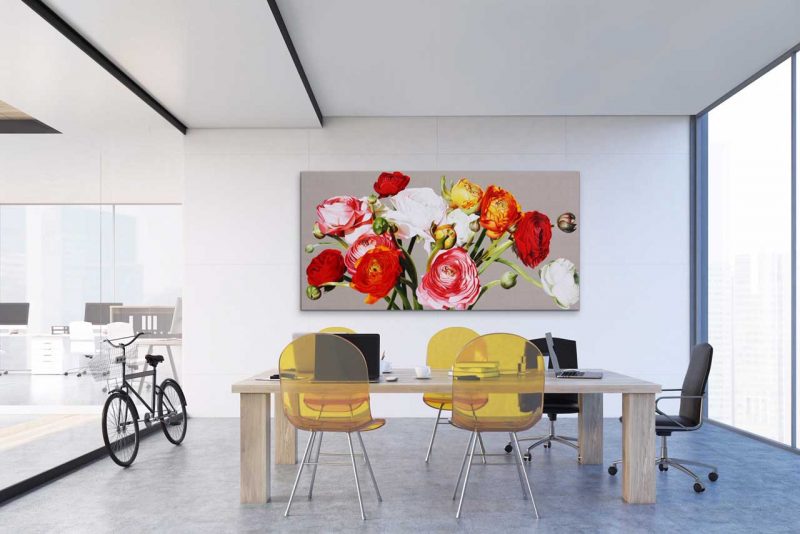 Canvas print of multi-coloured ranunculus on linen background on a wall in an office. Painting by UK floral artist Sarah Caswell