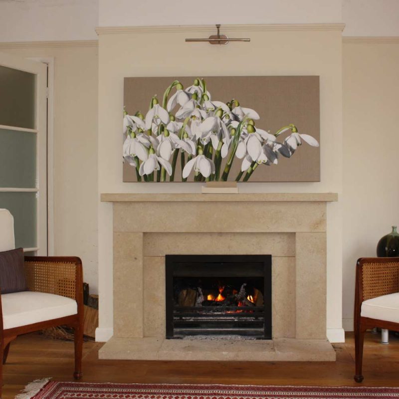 White snowdrops galanthus acrylic on linen painting by UK floral artist Sarah Caswell hung above a fireplace in a living room